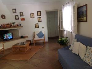 uma sala de estar com um sofá azul e uma televisão em Baia Delle Palme Beach em Santa Margherita di Pula