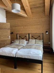 two beds in a room with wooden walls at Chalet Jasná Apartment Franco jacuzzi & sauna in Demanovska Dolina
