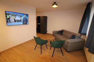 a living room with a couch and a table and chairs at DER Hirsch Hotel in Monschau