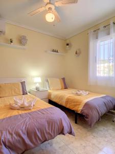 sypialnia z 2 łóżkami i oknem w obiekcie Butterfly Bungalow - 9009 w mieście Los Alcázares