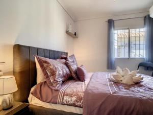 a bedroom with a bed with pillows and a window at Butterfly Bungalow - 9009 in Los Alcázares