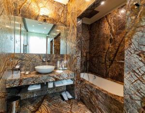 a bathroom with a sink and a bath tub at Villa Lario Resort Mandello in Mandello del Lario