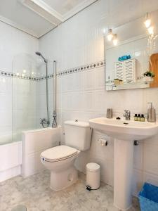 biała łazienka z toaletą i umywalką w obiekcie Butterfly Bungalow - 9009 w mieście Los Alcázares
