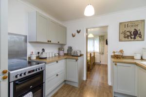 a kitchen with white cabinets and a stove top oven at Queen Bower Farm Lodge in Alverstone