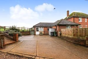 a brick house with a fence and a driveway at Queen Bower Farm Lodge in Alverstone