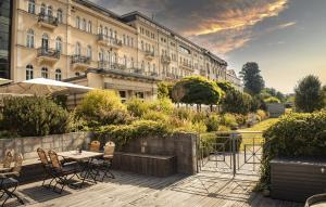 un patio con mesa y sillas frente a un edificio en Hotel Elbresidenz an der Therme en Bad Schandau