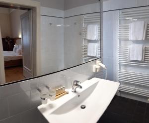 a bathroom with a white sink and a mirror at Hotel Okresní Dům in Hradec Králové