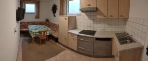 een keuken met een tafel, een wastafel en een fornuis bij Haus-Elisabeth in Uderns