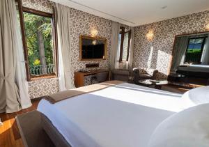 a bedroom with a large white bed in a room at Villa Lario Resort Mandello in Mandello del Lario