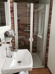 a bathroom with a white sink and a shower at Hotel Austria in Bad Hofgastein