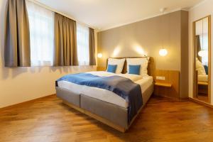 Habitación de hotel con cama grande con sábanas azules en Hotel Wilder Mann en Meersburg