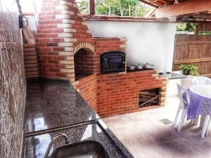 a brick fireplace in a patio with a table at Pousada Recanto das Oliveiras-Búzios in Búzios