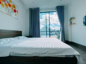 a bedroom with a large bed and a large window at Mia Homestay in Hoi An