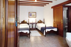 a bedroom with two beds and a table in it at Casa De La Eterna Primavera in San Bartolomé