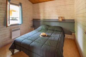 1 dormitorio con 1 cama con sombrero en Camping les Lacs d'Armagnac en Bretagne-dʼArmagnac