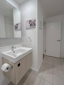 a white bathroom with a sink and a mirror at 1.5BR apartment Fortitude Valley in Brisbane