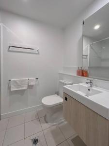 a white bathroom with a toilet and a sink at 1.5BR apartment Fortitude Valley in Brisbane