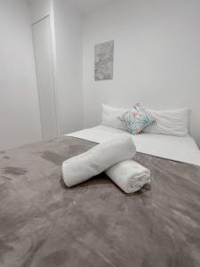 a white bed with a sculpture on the floor at 1.5BR apartment Fortitude Valley in Brisbane
