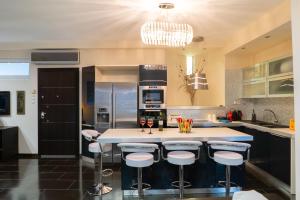 a kitchen with a large island with bar stools at Villa Sea View in Volos