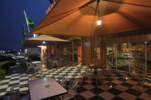 - un restaurant avec des tables et des chaises sur un sol en damier dans l'établissement Hotel Emira, à Nouakchott