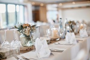 einen Tisch mit Gläsern und Blumen in einem Zimmer in der Unterkunft Gasthaus Hotel Zum Mohren in Niederstotzingen