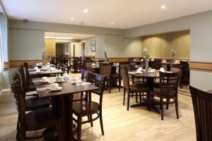 فندق فونيكس في لندن: غرفة طعام مليئة بالطاولات والكراسي
