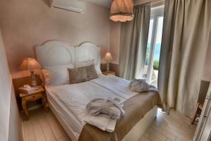 una camera da letto con un grande letto bianco con una finestra di BnB Borgo le Vigne - L'Uva rara Only Adults a Tignale