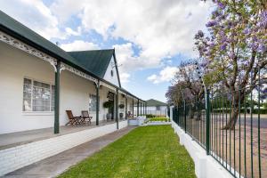 una valla al lado de una casa con un patio en Victorian Square Guesthouse en Graaff-Reinet