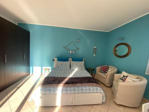 1 dormitorio azul con 1 cama y 1 silla en Bellagio lake flat en Bellagio