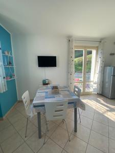 a dining room with a table with chairs and a television at Bellagio lake flat in Bellagio