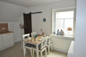 una cucina con tavolo, sedie e finestra di Ferienwohnung Martens 65344 a Moormerland