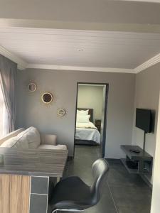 um quarto com um espelho, uma cadeira e uma cama em The Villa 442 em Pretoria
