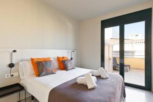 バルセロナにあるOla Living Merceのベッドルーム(オレンジ色の枕が付いた大きな白いベッド付)