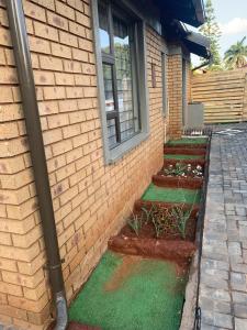 a brick house with a window and some grass at The Villa 442 in Pretoria
