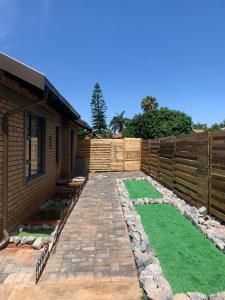 a backyard with a fence and a lawn at The Villa 442 in Pretoria