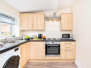 a kitchen with wooden cabinets and a dishwasher at The Nest in Helmsley