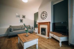 sala de estar con sofá, TV y chimenea en Norton Village View By Horizon Stays, en Stockton-on-Tees