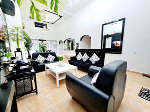 a living room with couches and a table at Private 4Bedroom Villa Pool,BBQ,Karaoke, Afamosa Resort in Kampong Alor Gajah