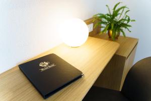 einen Laptop auf einem Schreibtisch mit einer Lampe in der Unterkunft Hotel Wilder Mann in Meersburg