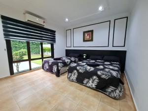 a bedroom with two beds and a large window at Private 4Bedroom Villa Pool,BBQ,Karaoke, Afamosa Resort in Kampong Alor Gajah +40 photos
