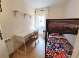 a bedroom with a bed and a desk next to a bed at Acogedor piso en el centro de Sabiñanigo in Sabiñánigo