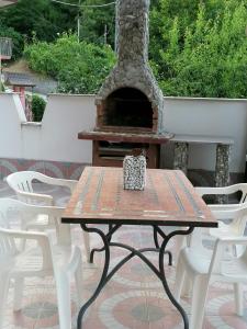 einen Picknicktisch mit einem Pizzaofen auf einer Terrasse in der Unterkunft La casa di Pina in Latronico
