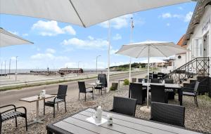 a restaurant with tables and chairs and an umbrella at Tante Tut & Onkel E - B & B - Hotel in Kolby Kås