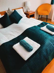 - un lit avec 2 serviettes assises au-dessus dans l'établissement Rossalini Apartment with FREE Parking, à Budapest