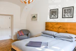 um quarto com uma cama grande e uma cadeira em Beautiful 2bed apartment in the centre of Varazdin em Varaždin