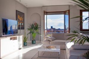 sala de estar con sofá y TV en Stelvio Rooftop - Penthouse skyline with terrace and jacuzzi, en Milán