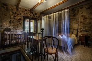 a bedroom with a bed and a table and a chair at La Voce del Fiume Dimora di Charme in Brienza