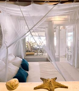 a bedroom with a bed with a canopy and two starfish at Casa na Praia Tofo- beach front hotel in Praia do Tofo