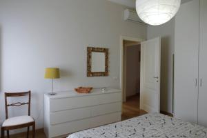 ルッカにあるYOURHOMEINLUCCA Le Palmeの白いベッドルーム(ドレッサー、鏡付)
