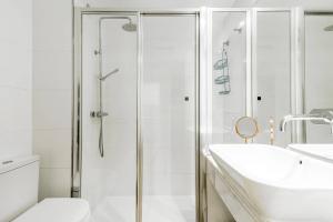 Un baño blanco con ducha y lavabo. en Casa Brasil - 1ª Linea Playa con Parking Incluido, en Cádiz 10 fotos más